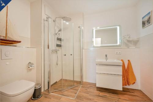 een badkamer met een douche, een toilet en een wastafel bij An der Haffküste Ferienwohnung Heimat Hafen in Zirchow