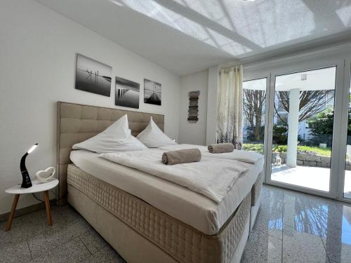um quarto branco com uma cama grande e uma janela em Seesicht em Überlingen
