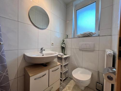 uma casa de banho com um lavatório, um WC e um espelho. em Seesicht em Überlingen