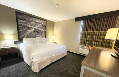 a hotel room with a large bed and a window at Super 8 by Wyndham St Charles in St. Charles
