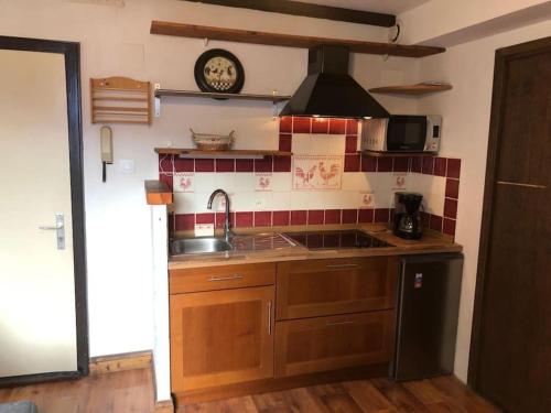 a kitchen with a sink and a clock on the wall at Studio Avalon I in Ribeauvillé
