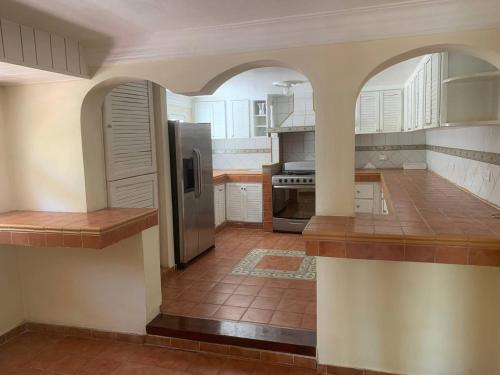 uma cozinha com um frigorífico e piso em azulejo em Rincon Andaluz em Santo Domingo