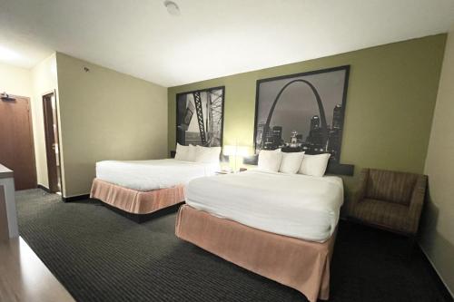 una habitación de hotel con 2 camas y una silla en Super 8 by Wyndham St Charles, en St. Charles
