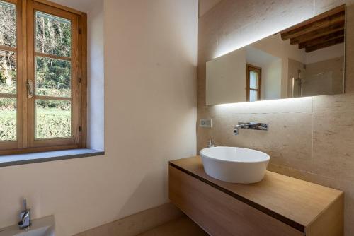a bathroom with a white sink and a window at Casa Bachella in Bagni di Lucca