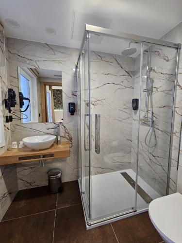 a bathroom with a shower and a sink at Pensión Casa Cruceiro in Arzúa