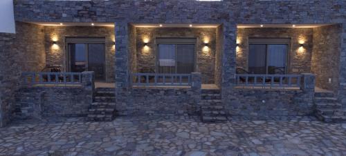 a building with two benches on the side of it at Aegeans Eye in Azolimnos