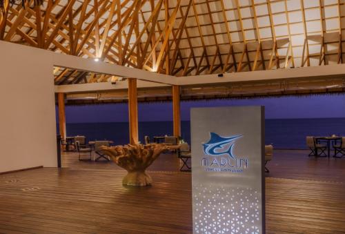 a large room with a table and a sign in the middle at Cinnamon Velifushi Maldives in Keyodhoo