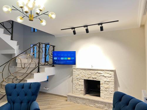 uma sala de estar com lareira e uma escada em Mount Inn Villa em Bakuriani