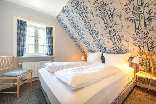 a bedroom with a bed and a chair and a window at Durango in Keitum