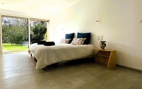 - une chambre avec un lit et une grande fenêtre dans l'établissement Villa Luxe 5 min du Circuit 7 ch 14 pers Piscine Chauffée privée, à Arnage