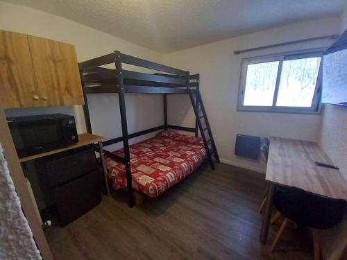 a bedroom with a bunk bed with a red bedspread at Studio plein centre des 2 Alpes in Les Deux Alpes