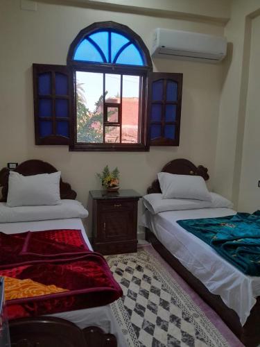 a room with two beds and a window at Osiris Guest House in Abu Simbel