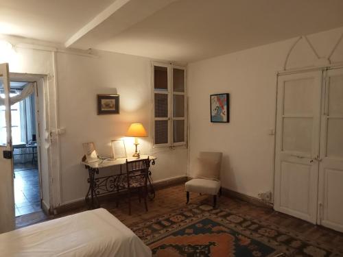 a bedroom with a bed and a desk with a lamp at Le Mas Palegry Chambres d'hôtes Perpignan in Perpignan
