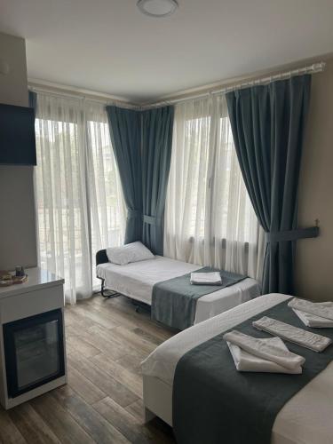 ein Hotelzimmer mit 2 Betten und einem Kamin in der Unterkunft AURORA SIĞACIK HOTEL in Seferihisar