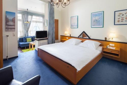 a bedroom with a large bed and a living room at Strandkorb in der Villa Medici in Norderney