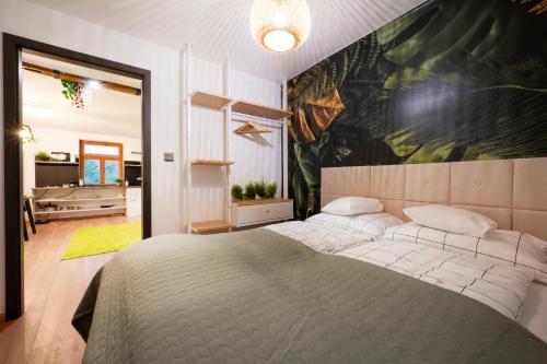 a bedroom with a bed and a large painting on the wall at Picnic Lux 2plus2 Centrum in Kőszeg