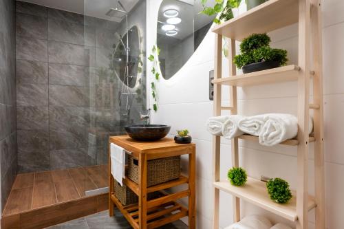 a bathroom with a shower and a wooden shelf with plants at Picnic Lux 2plus2 Centrum in Kőszeg