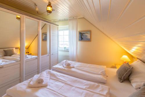 um quarto com duas camas e um espelho em Wandalennest em Greetsiel