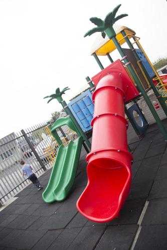 a playground with a red slide and a green slide at The Frontier Hotel in Bridgend