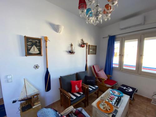a living room with a couch and an umbrella on the wall at Yacht Marine Maison in Naxos Chora