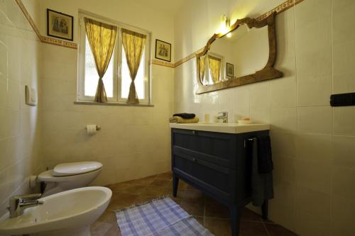 a bathroom with a sink and a toilet and a mirror at A Munta di Povei in Casarza Ligure