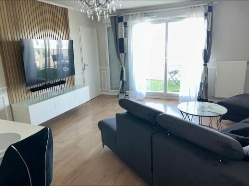 un salon avec un canapé et une table dans l'établissement LIMA HOUSE, à Goussainville