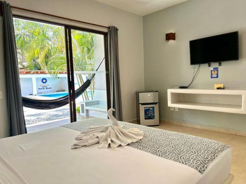 a bedroom with a bed with a view of a balcony at Hotel Aldea Sol in Zihuatanejo