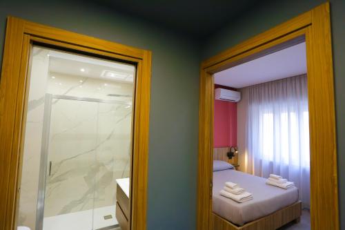a room with a bed and a glass door to a shower at RIDA 33 Vomero in Naples