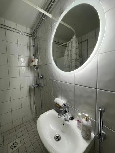 La salle de bains est pourvue d'un lavabo et d'un miroir. dans l'établissement VesiLahti RoofLevel Apartment, à Lahti