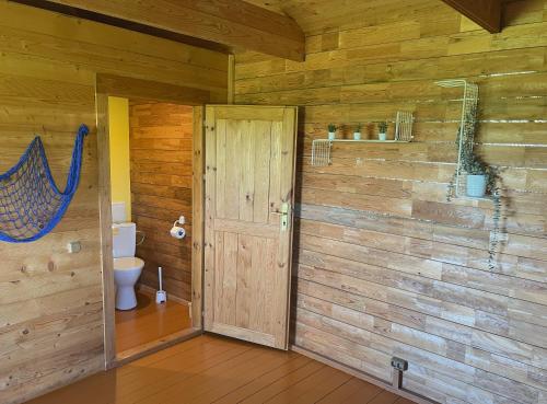 uma casa de banho com um WC e um chuveiro em Vītolu dīķi - atpūtas mājiņas ar makšķerēšanu em Durbe