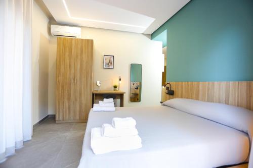 a bedroom with a white bed and a blue wall at RIDA 33 Vomero in Naples