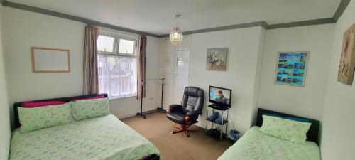 1 Schlafzimmer mit 2 Betten, einem Stuhl und einem Fenster in der Unterkunft Plymouth Airbnb in Plymouth