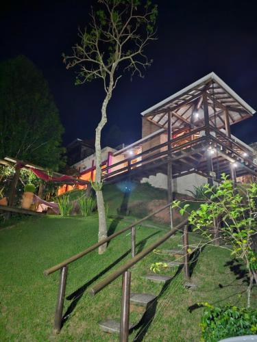 budynek z mostem w parku w nocy w obiekcie Pousada Vinhas do Pinhal w mieście Santo Antônio do Pinhal