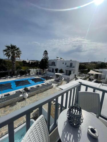 a balcony with a table and chairs and a swimming pool at Zoumis Residence in Naousa