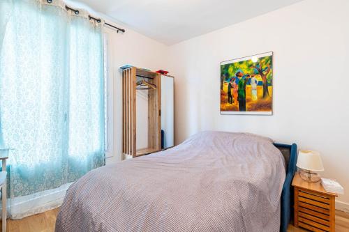 une chambre avec un lit et un tableau au mur dans l'établissement GuestReady - Cozy Retreat near Place de la Nation, à Paris