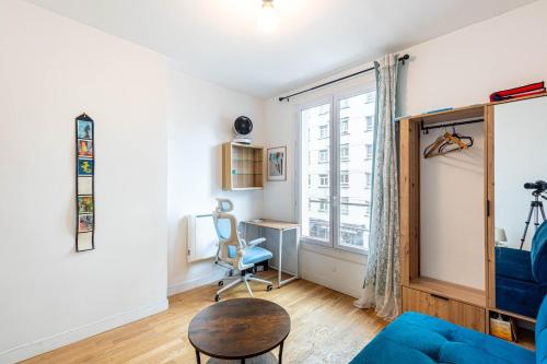 - un salon avec un canapé bleu et un bureau dans l'établissement GuestReady - Cozy Retreat near Place de la Nation, à Paris