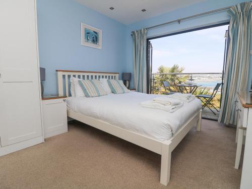 a bedroom with a bed and a large window at Rose Villa in Newlyn