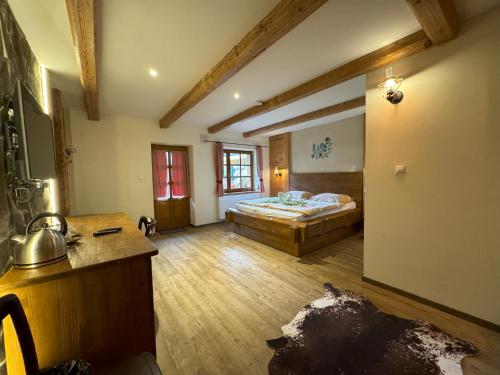 a large room with a bed and a wooden floor at Chata Piecky in Hrabušice