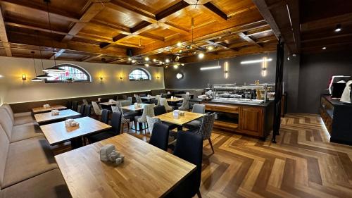 a restaurant with wooden tables and chairs and a counter at Pensjonat Sekuła*** in Bukowina Tatrzańska