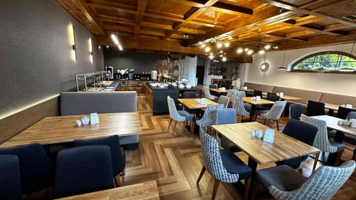 a restaurant with wooden tables and blue chairs at Pensjonat Sekuła*** in Bukowina Tatrzańska
