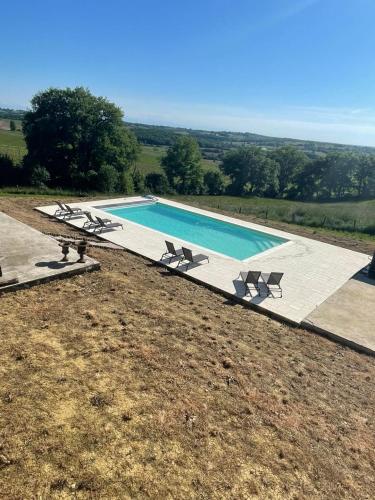 - une vue sur la piscine et ses 2 chaises longues dans l'établissement Maison Cabet, à Castelnavet