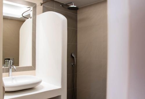 a bathroom with a sink and a shower at Sellada Beach in Perissa