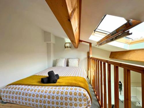 Cet appartement comprend une chambre dotée d'un lit et d'une lucarne. dans l'établissement Le Quai des Orchidées - Climatisation - Netflix, à Montpellier