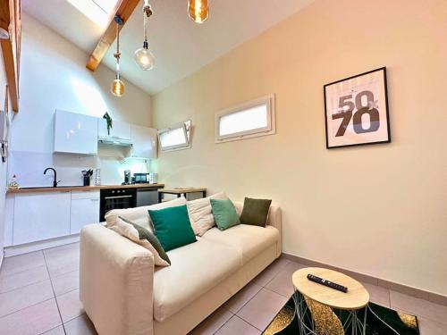 un salon avec un canapé et une table dans l'établissement Le Quai des Orchidées - Climatisation - Netflix, à Montpellier