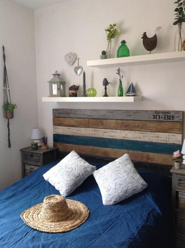 - un lit avec un chapeau de paille au-dessus dans l'établissement T2 vue Mer avec balcon, climatisé, piscine, à Saint-Cyr-sur-Mer