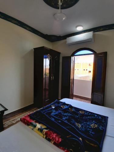 a bedroom with a bed with a blanket on it at Osiris Guest House in Abu Simbel