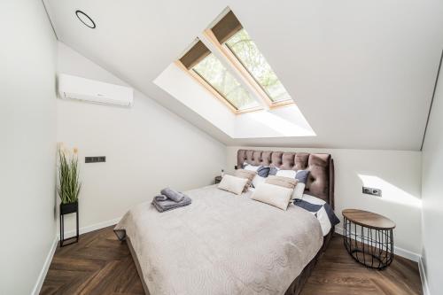 a bedroom with a large bed with a skylight at Riverra House - Two-bedroom Apartment in Kaunas