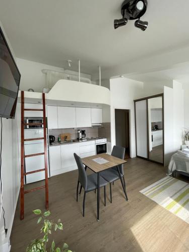 een keuken met een tafel en stoelen in een kamer bij VesiLahti RoofLevel Apartment in Lahti