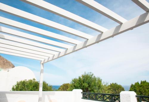 a white pergola with a view of the ocean at Sellada Beach in Perissa