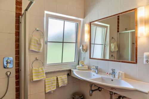 een badkamer met een wastafel en een spiegel bij Landhaus Sonnenzauber in Oberau